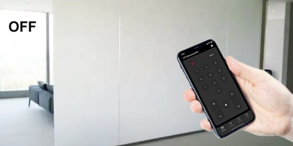 Une main tient un smartphone devant un mur blanc, son écran affichant une application permettant de contrôler des appareils. Le mot « OFF » apparaît subtilement sur le mur, comme s'il avait été conçu par la technologie 💡 Film dépoli à cristaux liquides.